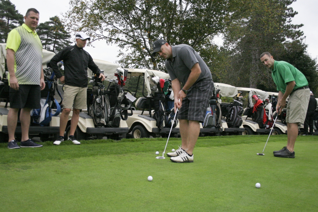 Jeff Gallusser, '01, and Matt Miller, '98, practice their putting on the green shortly before tee off at the Oneonta Country Club, who hosted the Alumni Golf Tournament on Friday morning as part of OHS's Alumni weekend festivities.