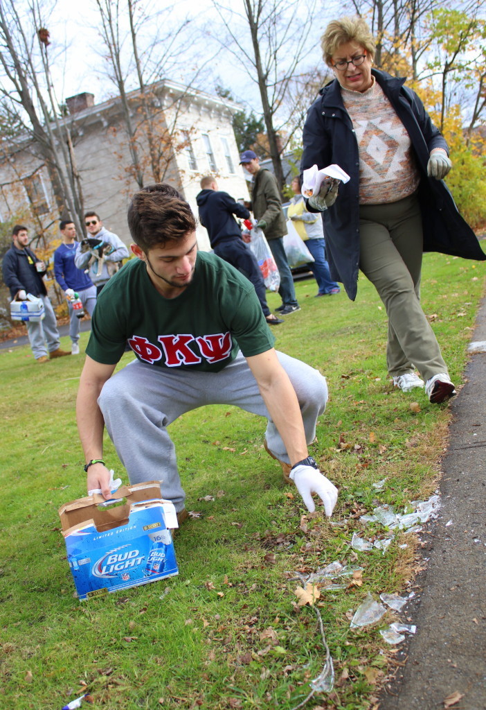 Evan Gerlack, a brother with Phi Kappa Psi, and 3rd ward resident Laurie Zimnewicz picks up trash and shattered glass off the lawn of 52 Elm St. in Oneonta. The two were participating with many others in the annual 3rd Ward clean-up, organized by council member David Rissberger. (Ian Ausitn/AllOTSEGO.com)