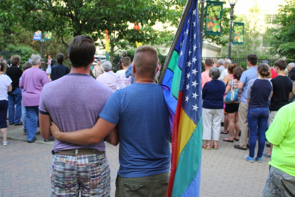 Jason Curley, left, Oneonta stands with his fiancé Chase Crupo among the crowd that gathered this evening in Muller Plaza for a candlelight vigil in response to the recent shooting at the Pulse nightclub Orlando, Fla. that left 49 dead and 53 injured. (Ian Austin/AllOTSEGO.com)